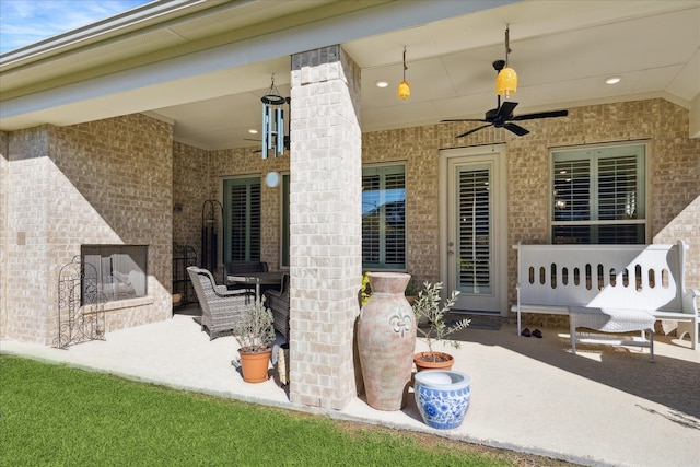 view of patio / terrace featuring ceiling fan and exterior fireplace