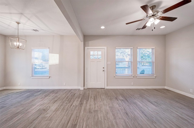 entryway with ceiling fan with notable chandelier and hardwood / wood-style flooring