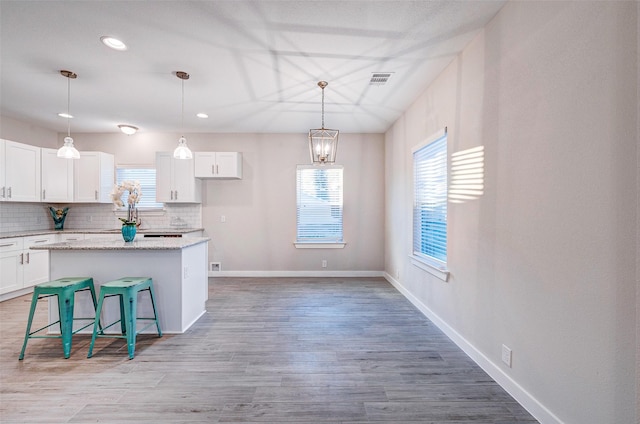 kitchen with white cabinets, a breakfast bar area, and a kitchen island