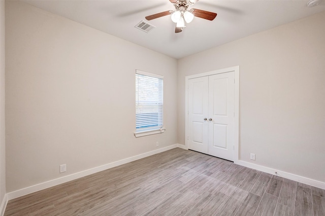 spare room with ceiling fan and light wood-type flooring