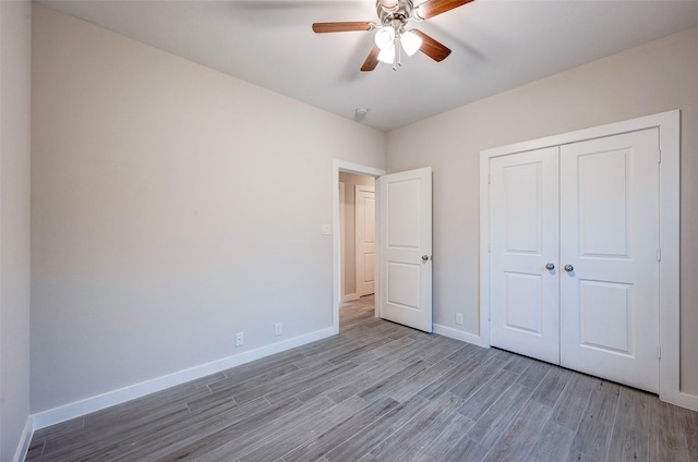 unfurnished bedroom featuring ceiling fan, a closet, and light hardwood / wood-style flooring