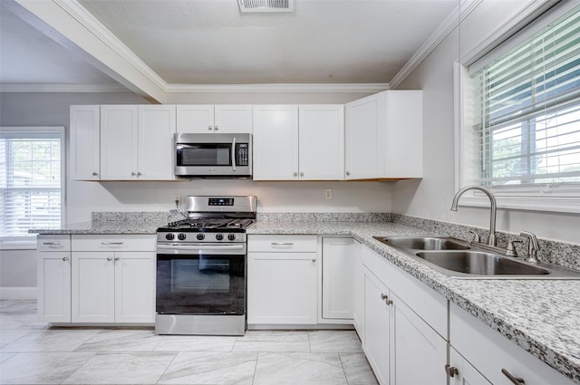 kitchen featuring appliances with stainless steel finishes, crown molding, white cabinets, and sink