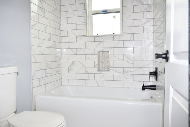 bathroom with toilet and tiled shower / bath