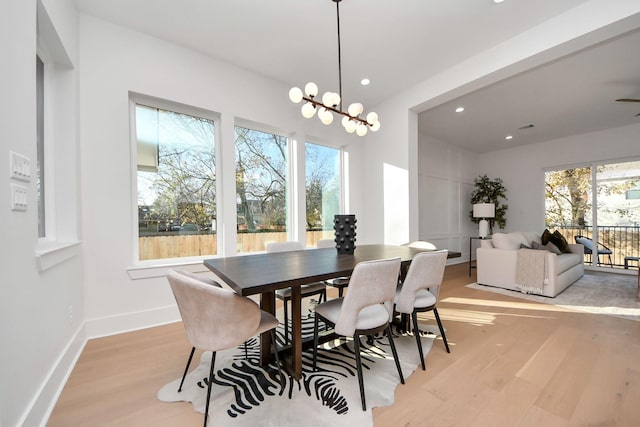 dining area with an inviting chandelier and light hardwood / wood-style flooring