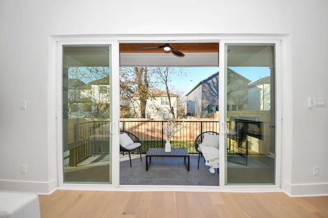 doorway featuring wood-type flooring and ceiling fan