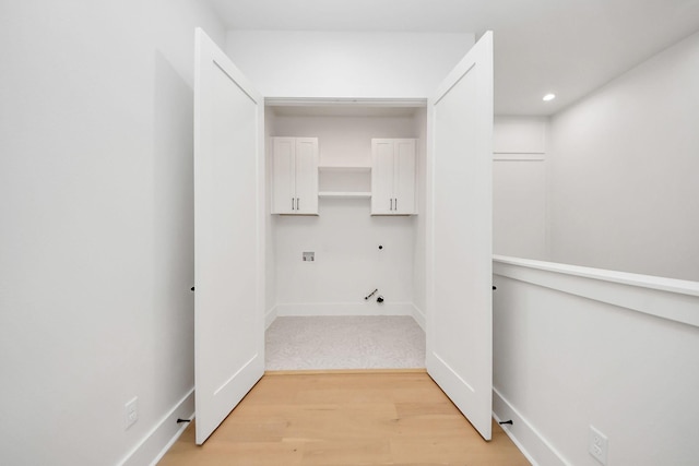 laundry area featuring cabinets and light hardwood / wood-style floors