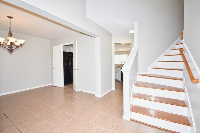 stairs with tile patterned flooring and a notable chandelier