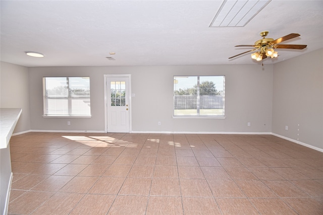 unfurnished living room featuring plenty of natural light, light tile patterned floors, and ceiling fan