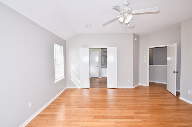 empty room with lofted ceiling, light hardwood / wood-style flooring, and ceiling fan