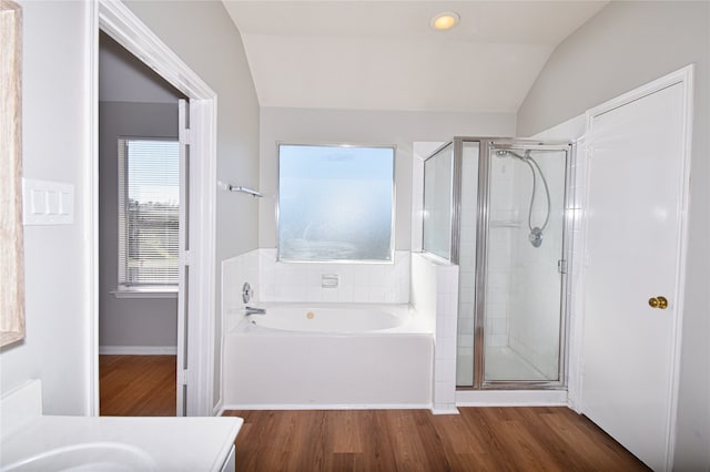 bathroom featuring vanity, independent shower and bath, vaulted ceiling, and hardwood / wood-style floors