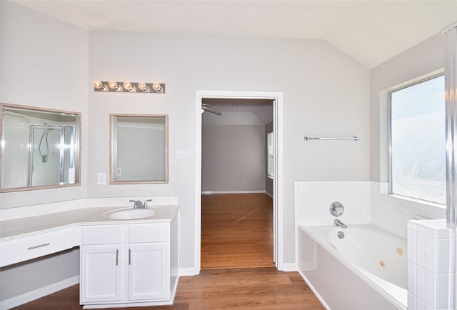 bathroom featuring vanity, hardwood / wood-style flooring, vaulted ceiling, and independent shower and bath