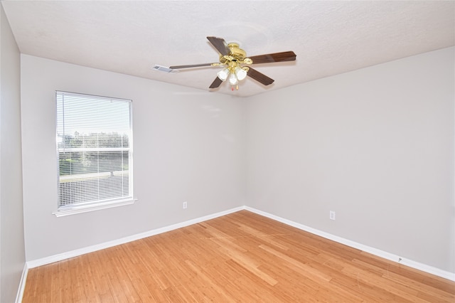 spare room featuring wood-type flooring and ceiling fan