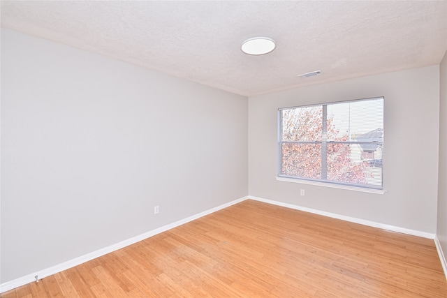 empty room featuring hardwood / wood-style floors and a textured ceiling