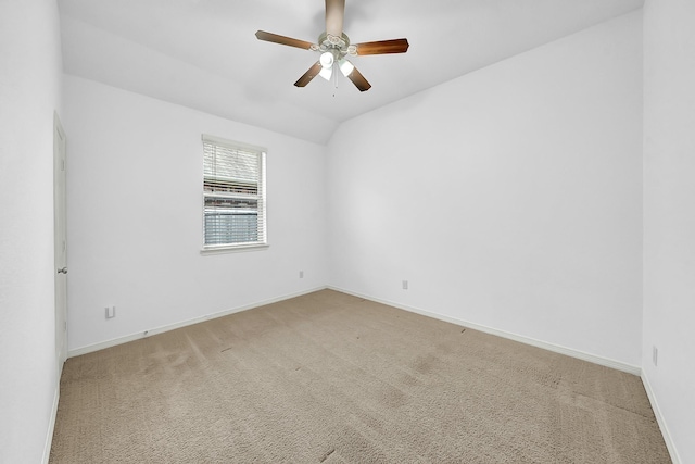 carpeted spare room with vaulted ceiling and ceiling fan