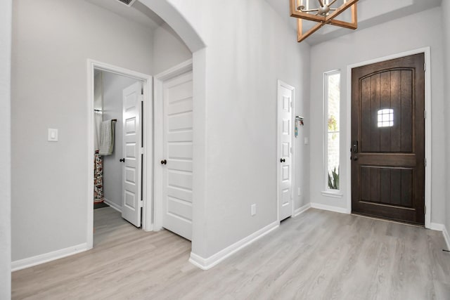 foyer with light wood-type flooring and a chandelier