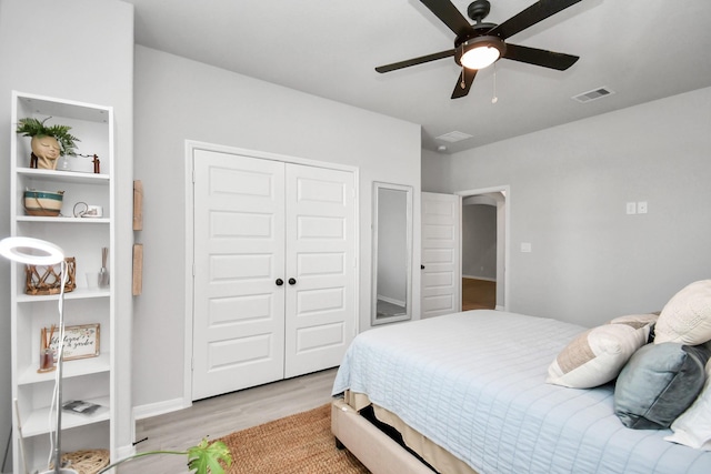 bedroom with ceiling fan, light hardwood / wood-style flooring, and a closet