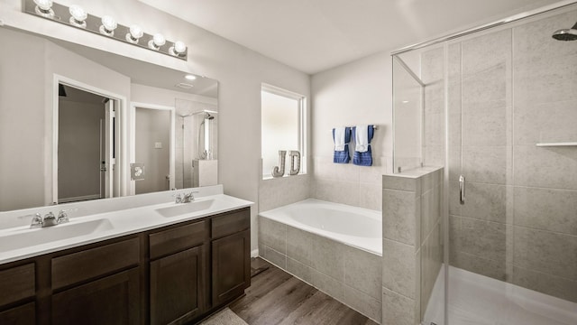 bathroom featuring hardwood / wood-style flooring, vanity, and shower with separate bathtub