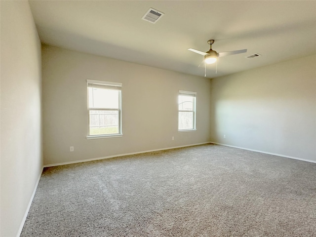 spare room featuring a wealth of natural light, carpet, and ceiling fan