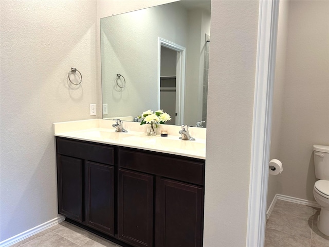 bathroom featuring toilet, vanity, and tile patterned flooring