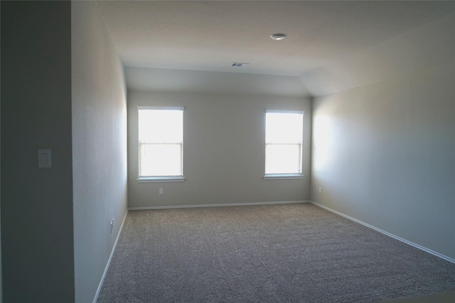 carpeted empty room featuring vaulted ceiling and a healthy amount of sunlight