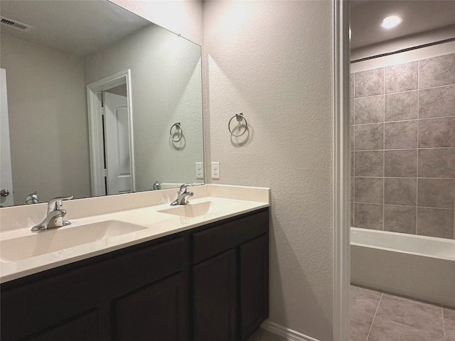 bathroom with tile patterned floors, tiled shower / bath, and vanity