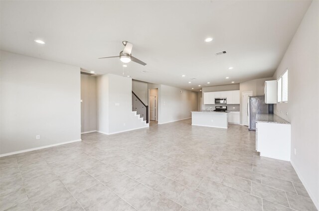 unfurnished living room featuring ceiling fan and light tile patterned floors