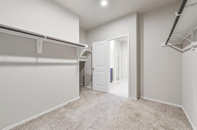 walk in closet with light carpet