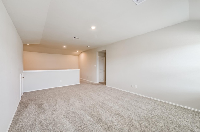 carpeted spare room featuring lofted ceiling