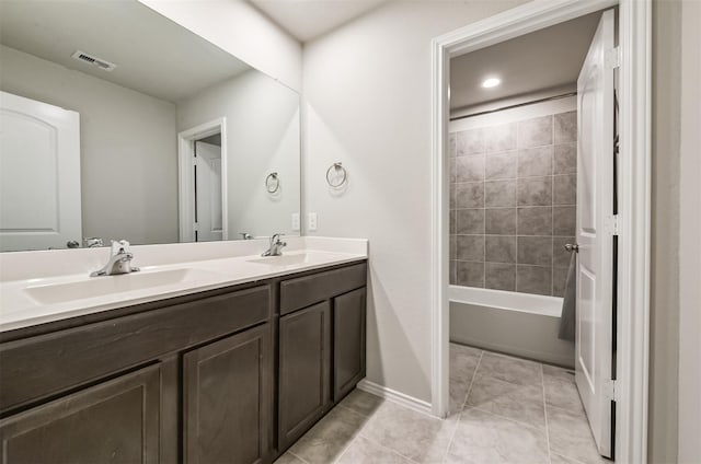 bathroom with tiled shower / bath combo, tile patterned floors, and vanity