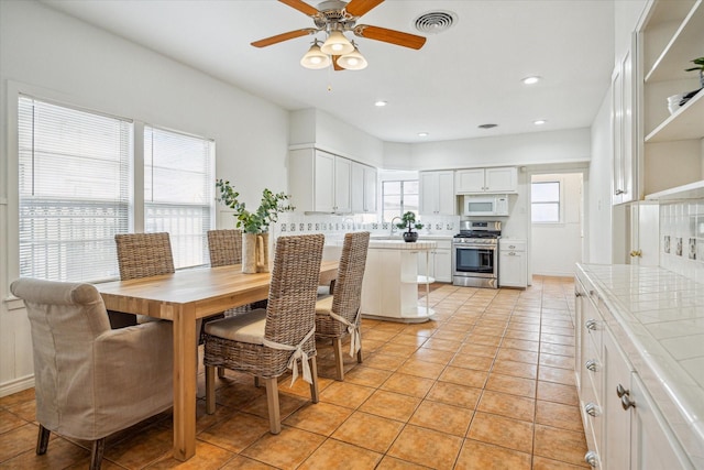 tiled dining room featuring sink and ceiling fan