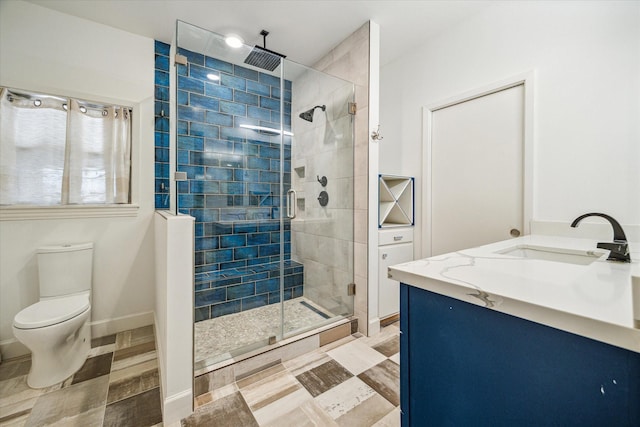 bathroom with vanity, toilet, and a shower with door