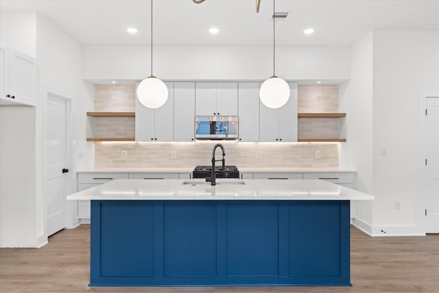 kitchen featuring decorative backsplash, white cabinets, and hanging light fixtures