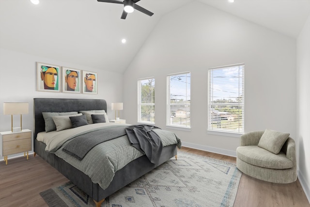 bedroom featuring ceiling fan, wood-type flooring, and high vaulted ceiling