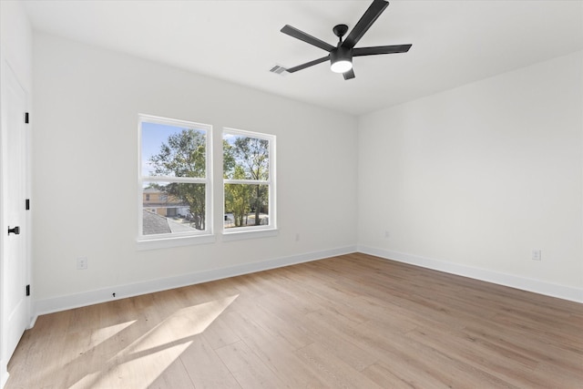 empty room with ceiling fan and light hardwood / wood-style flooring