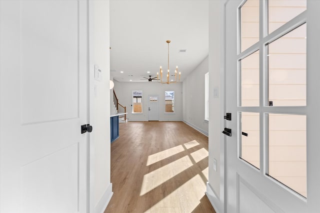 entrance foyer with light hardwood / wood-style floors and a notable chandelier