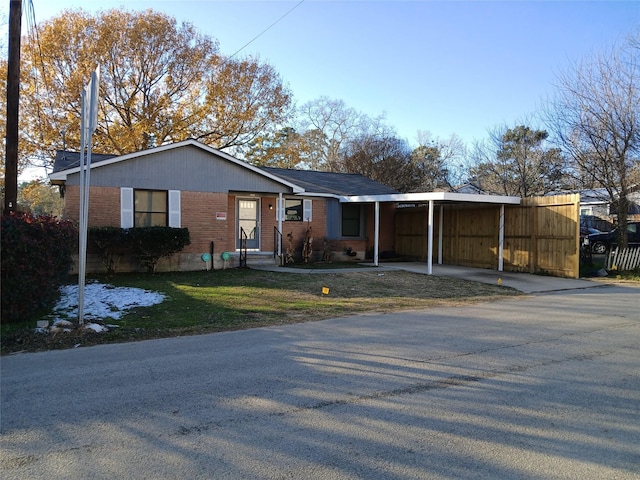 ranch-style house with a front yard and a carport