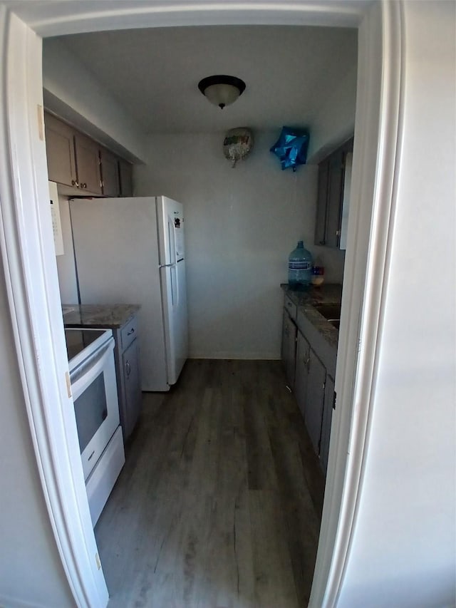 kitchen featuring white appliances and dark hardwood / wood-style floors