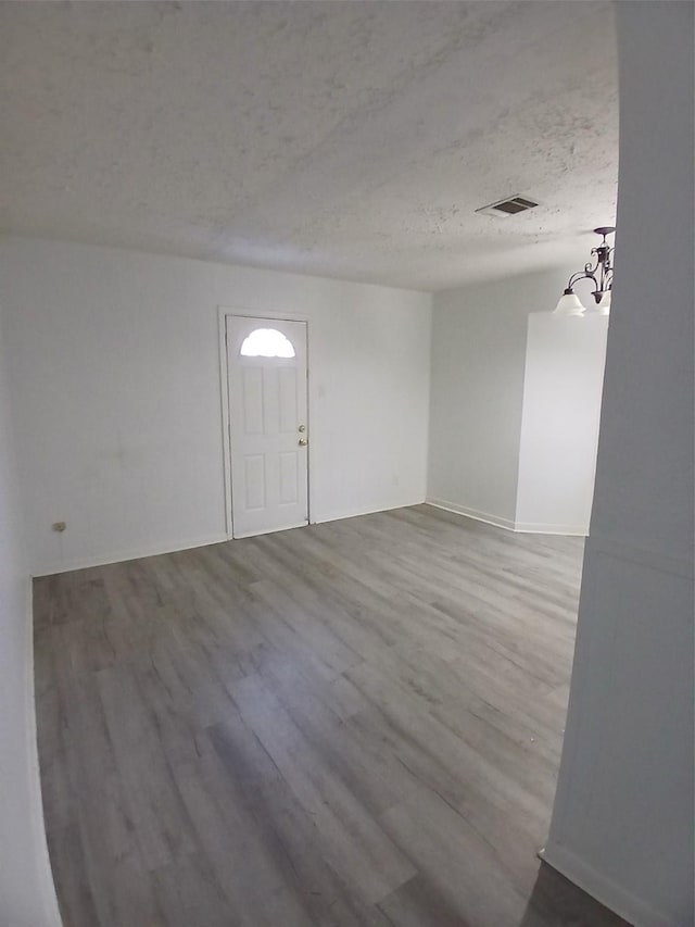 interior space with wood-type flooring and a textured ceiling