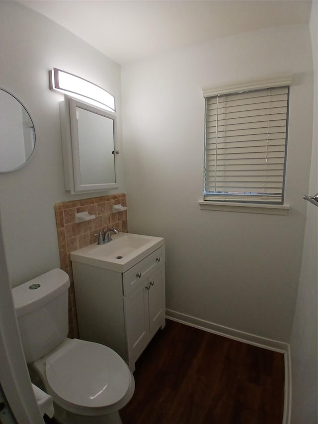 bathroom with hardwood / wood-style flooring, toilet, and vanity