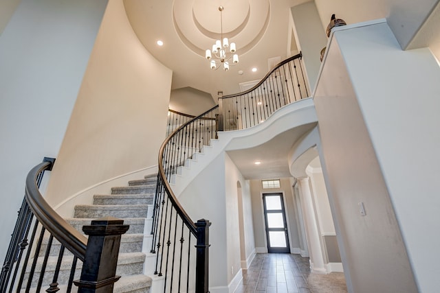 entryway with an inviting chandelier, a high ceiling, and decorative columns