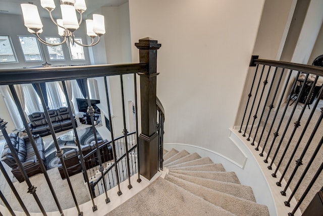 staircase with a chandelier