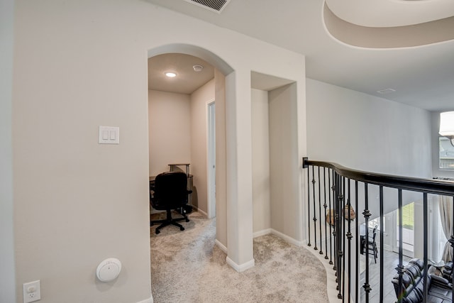 corridor with light colored carpet and a healthy amount of sunlight