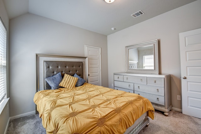 carpeted bedroom with lofted ceiling