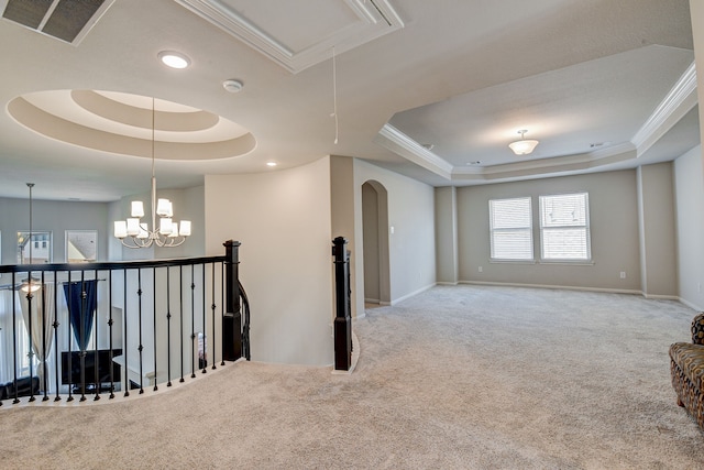 interior space featuring a raised ceiling, an inviting chandelier, and crown molding