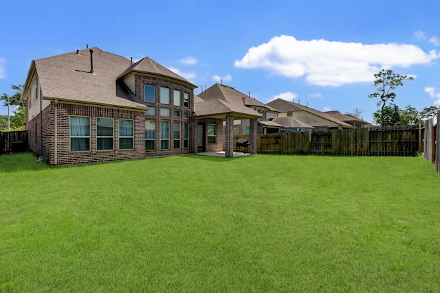 back of property with a lawn and a patio area