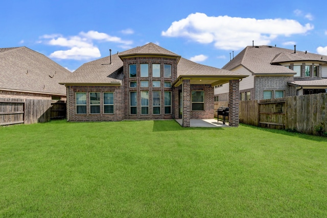 rear view of house with a lawn and a patio