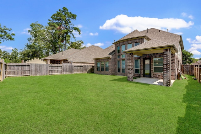 rear view of house with a patio area and a yard