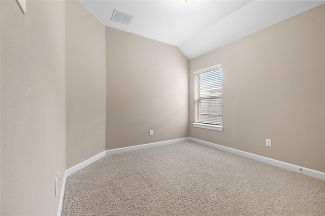 carpeted spare room with lofted ceiling