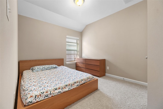 carpeted bedroom with lofted ceiling