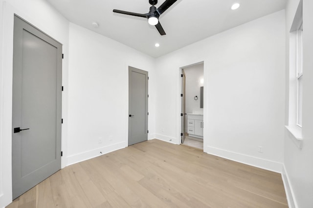 unfurnished bedroom featuring ceiling fan, ensuite bathroom, and light hardwood / wood-style floors